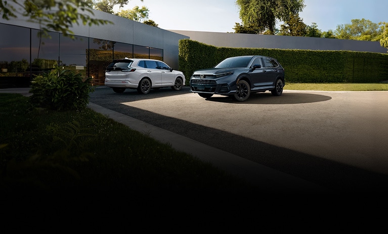2026 Honda CR-V and Honda Prologue front and back profile parked outside a modern building. 2026 Honda CR-V and Honda Prologue front and back profile parked outside a modern building.
