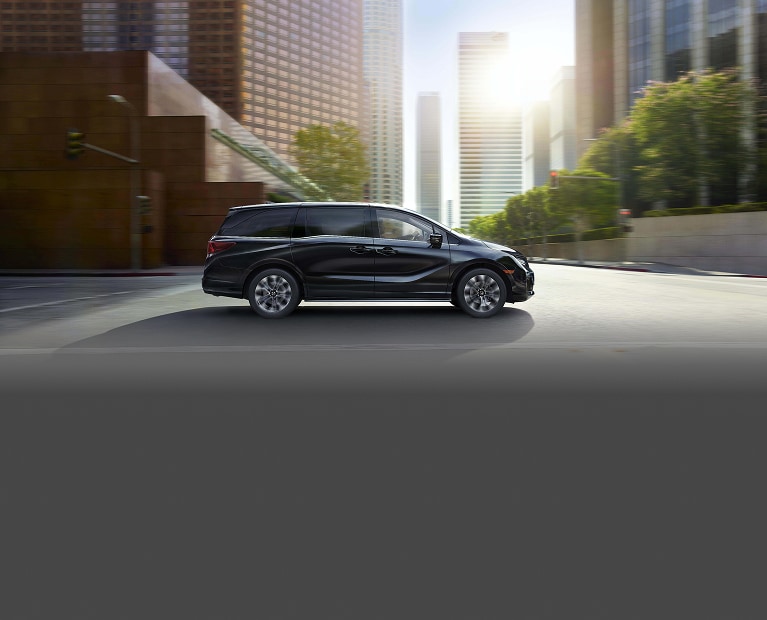 2027 Honda Odyssey Elite driving through city environment. 2027 Honda Odyssey Elite driving through city environment.