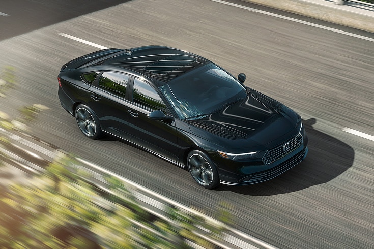 2026 Honda Accord Sport-L Hybrid in Crystal Black Pearl driving along overpass (Mid-Size Sedan). 2026 Honda Accord Sport-L Hybrid in Crystal Black Pearl driving along overpass (Mid-Size Sedan).